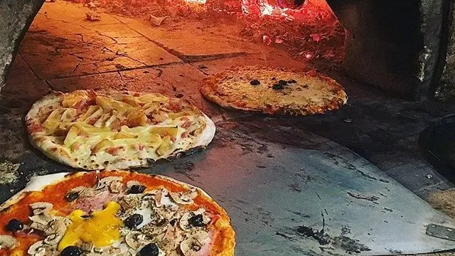 Pizzas qui cuisent dans le four à bois du restaurant